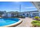 Community pool featuring blue water, brick patio, palms and lawn chairs at 1655 S Highland Ave # B110, Clearwater, FL 33756