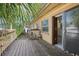 Rustic wooden deck leading to a sliding glass door, enhanced by surrounding foliage at 1910 Rainbow Dr, Clearwater, FL 33765