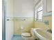 Retro bathroom with yellow and white tile, vintage fixtures, and a clean, functional layout at 1910 Rainbow Dr, Clearwater, FL 33765