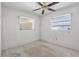 Bedroom featuring two windows, a ceiling fan, and awaiting personal touches for customization at 1910 Rainbow Dr, Clearwater, FL 33765