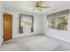 Bright bedroom with white walls, ceiling fan, and large windows at 1910 Rainbow Dr, Clearwater, FL 33765