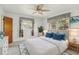 Bright bedroom with white walls, ceiling fan, large windows and stylish blue accents at 1910 Rainbow Dr, Clearwater, FL 33765