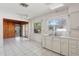 Bright kitchen featuring white cabinets, tile floor, ample counter space, and connection to other rooms at 1910 Rainbow Dr, Clearwater, FL 33765