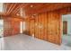 Open-concept living area featuring wood-paneled walls, tile flooring, and a view to other rooms at 1910 Rainbow Dr, Clearwater, FL 33765