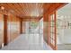 Spacious living room features wood paneled walls, tile floor, and sliding glass doors leading to the patio at 1910 Rainbow Dr, Clearwater, FL 33765