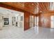 A spacious living area connects to the kitchen, featuring classic wood paneling and tile flooring at 1910 Rainbow Dr, Clearwater, FL 33765