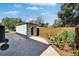 View of accessory building in backyard featuring modern hardscaping, privacy fence and tidy landscaping at 3106 Lila St, Tampa, FL 33610