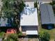 Well-maintained home featuring a white roof, green surroundings, and a cozy backyard space at 3106 Lila St, Tampa, FL 33610