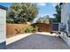 View of paved backyard with wooden fence and tropical landscaping at 3106 Lila St, Tampa, FL 33610