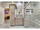 Bright bathroom features stone walls, a walk-in shower, and stylish cabinets and lighting at 3106 Lila St, Tampa, FL 33610