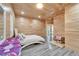 Wood paneled bedroom with a full bed, gray floors and connected bathroom at 3106 Lila St, Tampa, FL 33610