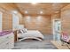 Wood-paneled bedroom with a cozy bed, gray floors, and plenty of natural light at 3106 Lila St, Tampa, FL 33610
