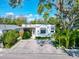 Charming single-story home featuring a modern design, lush landscaping, and a spacious brick driveway at 3106 Lila St, Tampa, FL 33610