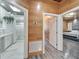 Hallway view highlighting the wood paneled walls, stylish flooring, and access to the bedroom and spa-like bathroom at 3106 Lila St, Tampa, FL 33610