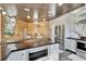 Open kitchen with a granite island, wood paneling, stainless steel appliances, white cabinets, and modern lighting at 3106 Lila St, Tampa, FL 33610