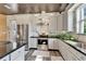 Open kitchen with stainless steel appliances, a granite island, white cabinets, and granite countertops at 3106 Lila St, Tampa, FL 33610