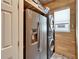 Close-up of the laundry room with refrigerator, washer/dryer, wood paneling and storage shelf at 3106 Lila St, Tampa, FL 33610