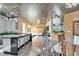 Open floor plan connects kitchen, living, and dining areas, featuring wood paneling and modern lighting at 3106 Lila St, Tampa, FL 33610
