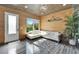 Bright living room featuring wood-paneled walls, and modern white sectional sofa at 3106 Lila St, Tampa, FL 33610