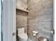 Stylish powder room features wood-look tile, a wall-mounted shelf, and modern fixtures at 3106 Lila St, Tampa, FL 33610