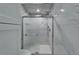Close-up view of the luxurious shower with marble walls, glass door, rainfall showerhead, and modern fixtures at 3106 Lila St, Tampa, FL 33610