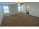 Sunlit bedroom with carpeted floors, a ceiling fan, and large windows at 35220 White Water Lily Way, Zephyrhills, FL 33541