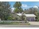 Charming green home with a white picket fence, two car garage, metal roof, and an American flag at 37136 Meridian Ave, Dade City, FL 33525