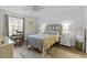 Inviting bedroom with decorative bedding, features a ceiling fan, bedside tables, and ample natural light at 3824 37Th S St # 65, St Petersburg, FL 33711
