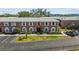 A well-maintained red brick condo building featuring green lawns, manicured shrubs, and a parking area at 3824 37Th S St # 65, St Petersburg, FL 33711
