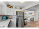 Bright kitchen featuring white cabinets and stainless steel appliances, seamlessly connected to a cozy living space at 3824 37Th S St # 65, St Petersburg, FL 33711
