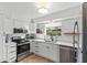 Modern kitchen with white cabinets, stainless steel appliances, and a bright window overlooking the outdoors at 3824 37Th S St # 65, St Petersburg, FL 33711