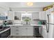 Well-lit kitchen boasts white cabinets, stainless steel appliances, and a garden window for a fresh, inviting feel at 3824 37Th S St # 65, St Petersburg, FL 33711