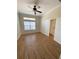 Bedroom with wood floors, ceiling fan, and large window with blinds at 415 Bayou Village Dr, Tarpon Springs, FL 34689