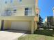 View of the garage with a balcony in a multi-story yellow condo building at 415 Bayou Village Dr, Tarpon Springs, FL 34689