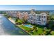 Stunning aerial view of waterfront condos with lush landscaping and pool overlooking beautiful blue waters at 4951 Bacopa S Ln # 103, St Petersburg, FL 33715