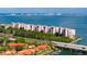 Aerial view of waterfront condos with ocean views and surrounding tropical landscaping, marina, and city skyline at 4951 Bacopa S Ln # 103, St Petersburg, FL 33715