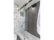 Sleek glass shower with marble wall, slate tile, and unique hexagon tile floor at 4951 Bacopa S Ln # 103, St Petersburg, FL 33715