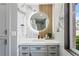 Stylish bathroom vanity featuring a lighted mirror, marble backsplash, and decorative wood accents at 4951 Bacopa S Ln # 103, St Petersburg, FL 33715