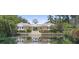 View of the elegant clubhouse with a pond and a large stairway leading up to the main entrance of the building at 4951 Bacopa S Ln # 103, St Petersburg, FL 33715