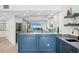 A modern kitchen with marble countertops and blue cabinets with a stunning water view at 4951 Bacopa S Ln # 103, St Petersburg, FL 33715