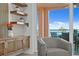 Cozy chair next to cabinets and shelves, with a view of the water and sky from sliding glass doors at 4951 Bacopa S Ln # 103, St Petersburg, FL 33715