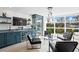Bright living room features a wine bar, wine fridge and modern furniture around large windows at 4951 Bacopa S Ln # 103, St Petersburg, FL 33715