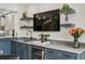 Living room featuring floating shelves, a bar, wine fridge, stunning counter tops and a mounted TV at 4951 Bacopa S Ln # 103, St Petersburg, FL 33715