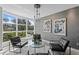Cozy living room seating area is highlighted by modern art and large windows with an airy feel at 4951 Bacopa S Ln # 103, St Petersburg, FL 33715