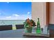 Close-up of the outdoor dining area with views of the water, flowers, and an appetizer set on the table at 4951 Bacopa S Ln # 103, St Petersburg, FL 33715