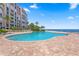 Inviting swimming pool surrounded by brick pavers, tropical landscaping, and lounge chairs with ocean view at 4951 Bacopa S Ln # 103, St Petersburg, FL 33715