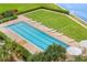 Overhead view of the community pool surrounded by lush landscaping, lounge chairs, and manicured lawn space at 4951 Bacopa S Ln # 103, St Petersburg, FL 33715