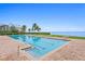 Inviting pool area with deck chairs and palm trees offering a serene waterfront view at 4951 Bacopa S Ln # 103, St Petersburg, FL 33715
