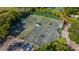 Overhead view of well-maintained tennis courts with parking and green space, surrounded by tropical trees and foliage at 4951 Bacopa S Ln # 103, St Petersburg, FL 33715