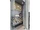 Wine cellar displays wine bottles on light wood and black shelving with a glass front at 4951 Bacopa S Ln # 103, St Petersburg, FL 33715